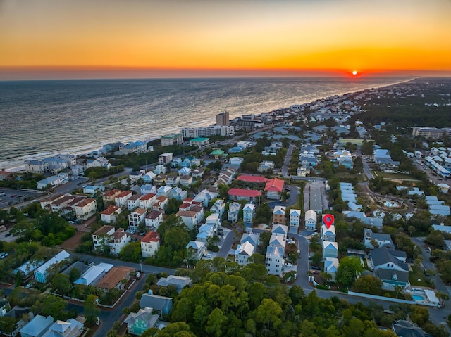 aerial view at dusk featuring a water view