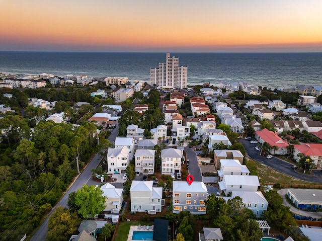 aerial view at dusk featuring a water view