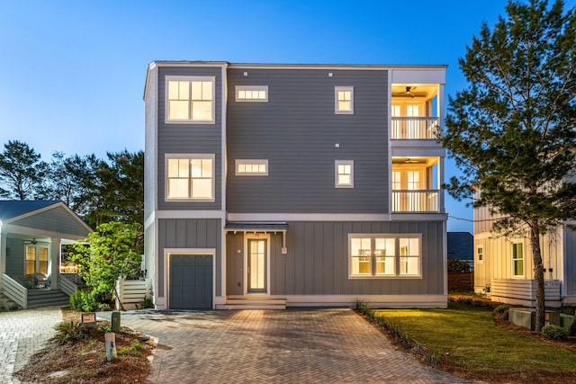 view of front of home featuring a balcony, a garage, and ceiling fan