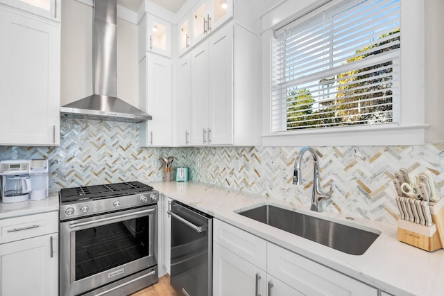 kitchen featuring white cabinetry, wall chimney exhaust hood, and stainless steel appliances