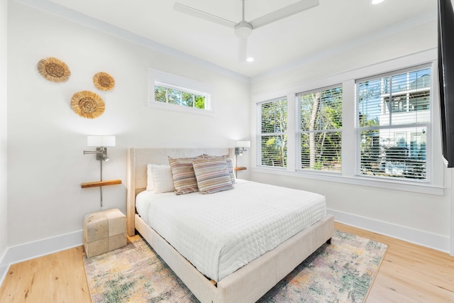 bedroom with ceiling fan, ornamental molding, and hardwood / wood-style flooring