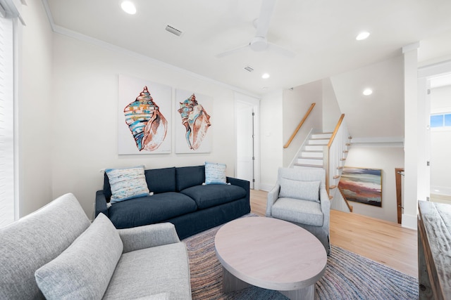 living room featuring hardwood / wood-style flooring, ceiling fan, and ornamental molding