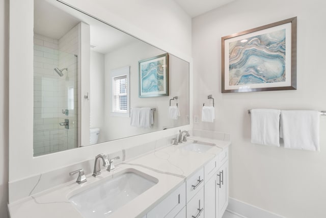 bathroom with tiled shower, vanity, and toilet