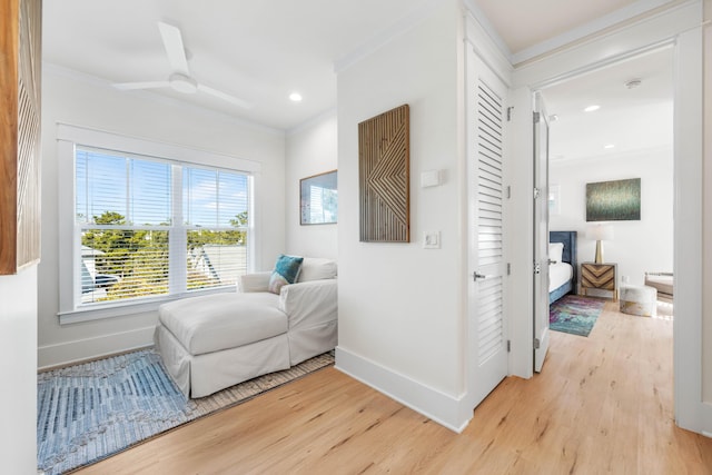 sitting room with ceiling fan, ornamental molding, and light hardwood / wood-style flooring