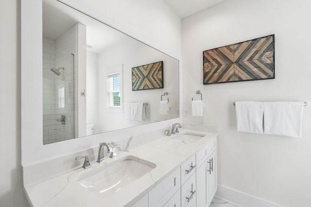 bathroom featuring vanity, toilet, and a tile shower