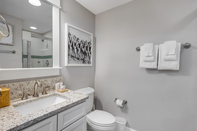 bathroom with toilet, vanity, and walk in shower