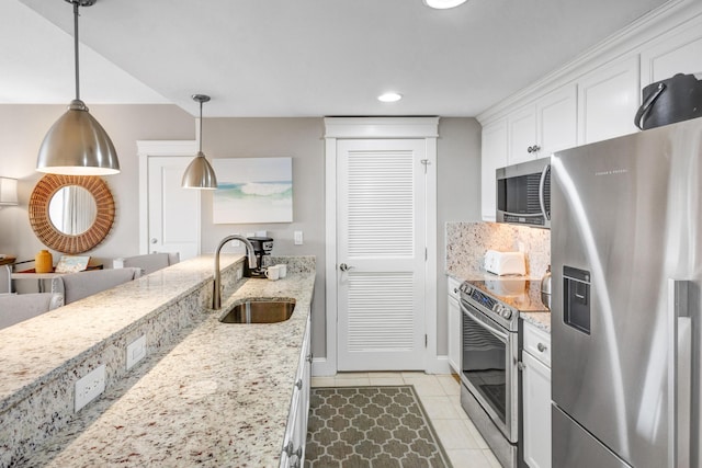 kitchen featuring white cabinets, sink, light stone countertops, appliances with stainless steel finishes, and decorative light fixtures