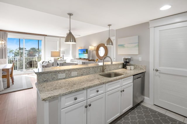 kitchen featuring hardwood / wood-style floors, dishwasher, white cabinets, sink, and decorative light fixtures