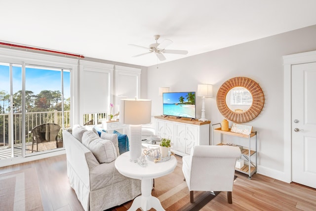 living room featuring ceiling fan and light hardwood / wood-style floors