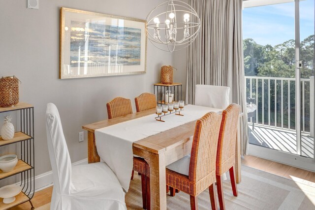 dining room with plenty of natural light, an inviting chandelier, and light wood-type flooring