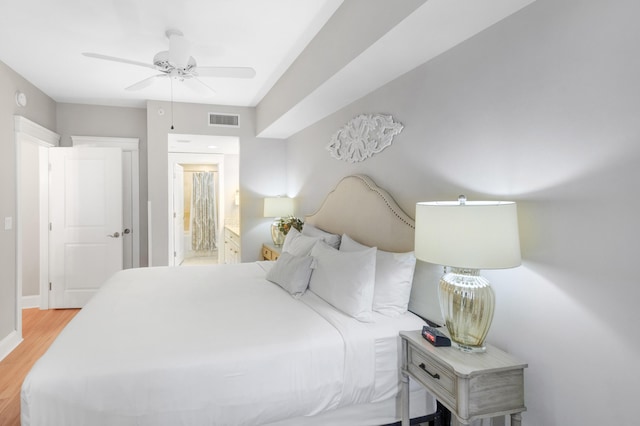 bedroom featuring ceiling fan, ensuite bathroom, and light wood-type flooring