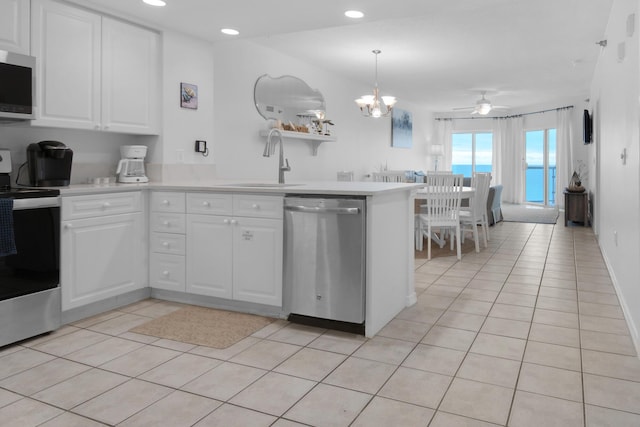 kitchen featuring sink, kitchen peninsula, pendant lighting, ceiling fan with notable chandelier, and appliances with stainless steel finishes