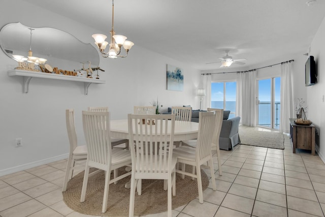 dining area featuring light tile patterned flooring and ceiling fan with notable chandelier