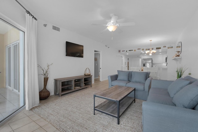 tiled living room featuring ceiling fan with notable chandelier