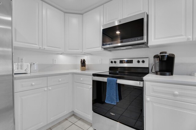 kitchen featuring white cabinets, light tile patterned floors, and appliances with stainless steel finishes