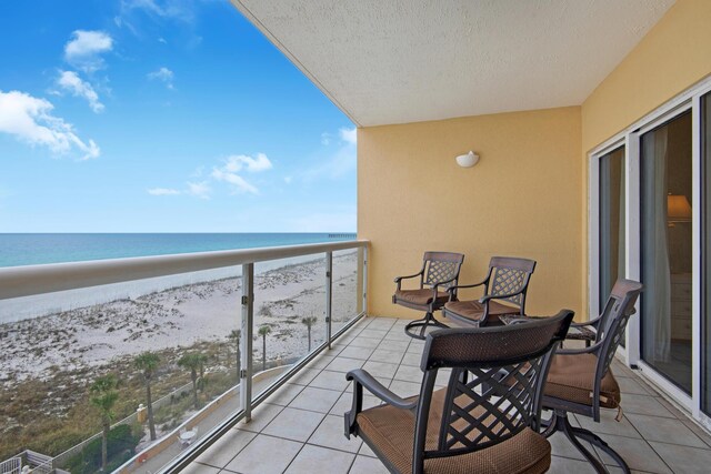 balcony with a water view and a beach view