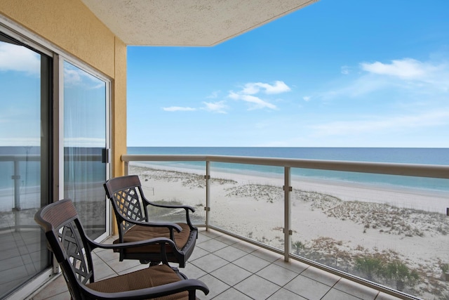 balcony featuring a beach view and a water view