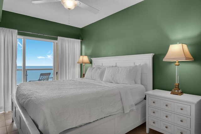 bedroom featuring access to outside, ceiling fan, a water view, and light tile patterned flooring