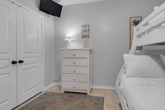 bedroom featuring light tile patterned floors and a closet