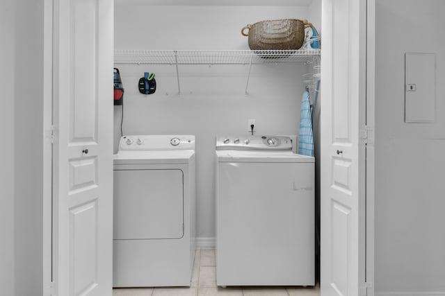 washroom with independent washer and dryer, electric panel, and light tile patterned floors