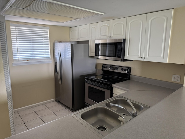 kitchen featuring a sink, white cabinets, appliances with stainless steel finishes, and light tile patterned floors