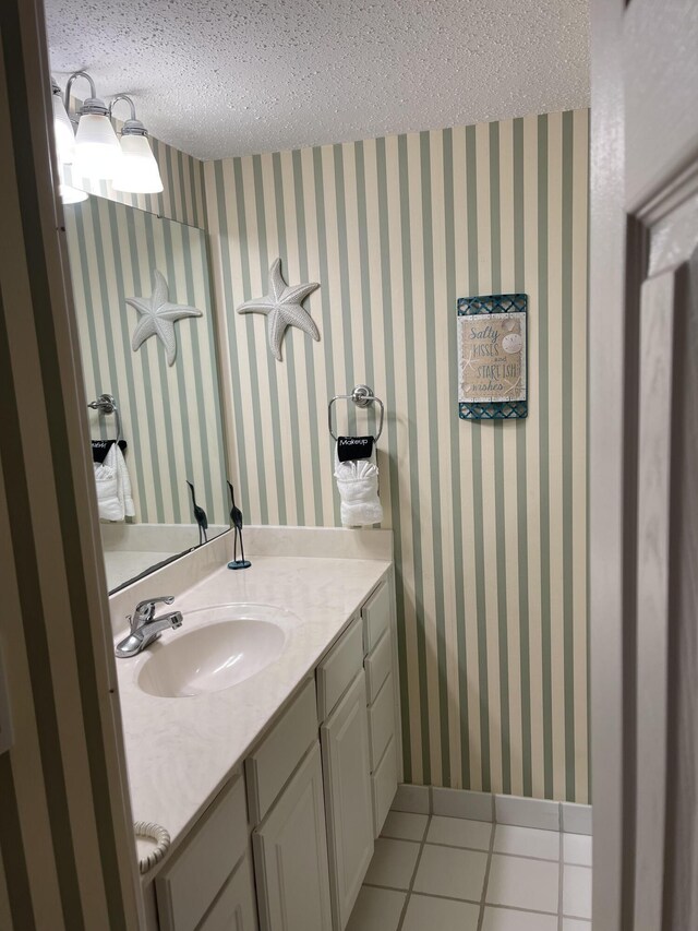 bathroom featuring tile patterned flooring, vanity, and a textured ceiling