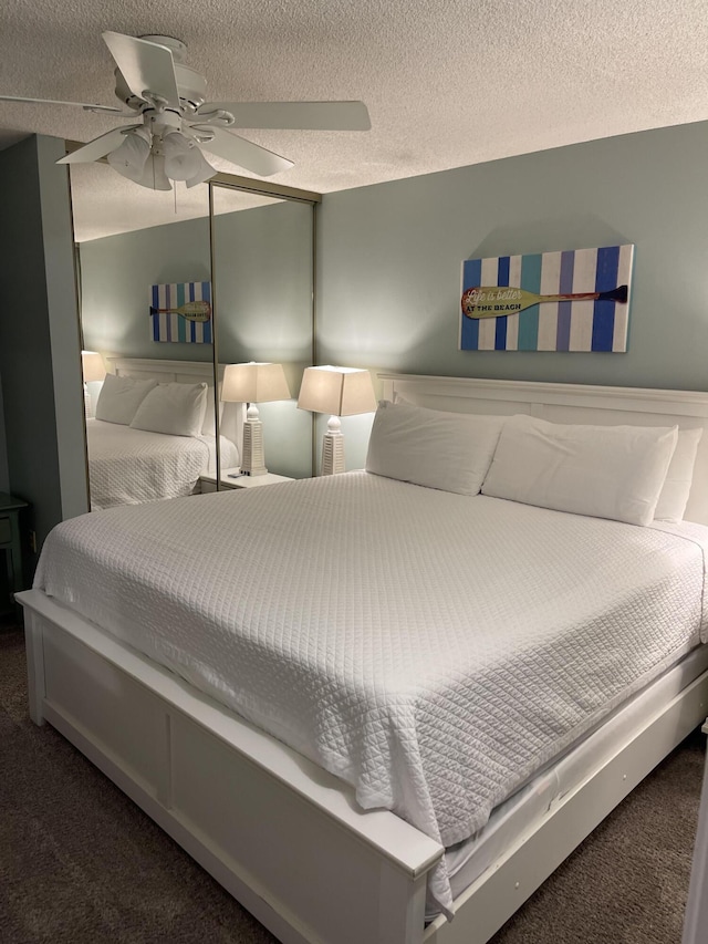 carpeted bedroom with a textured ceiling and ceiling fan