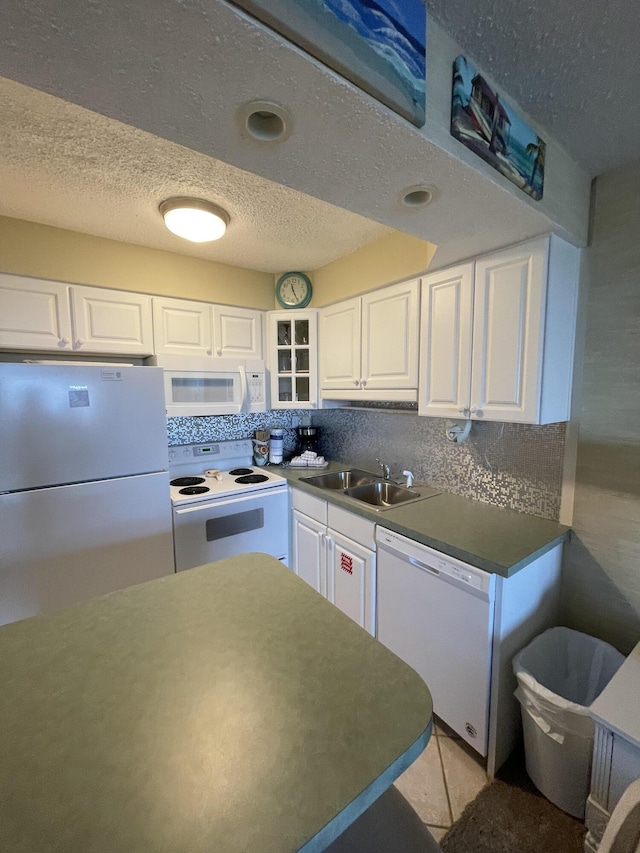 kitchen with white cabinets, backsplash, white appliances, and sink