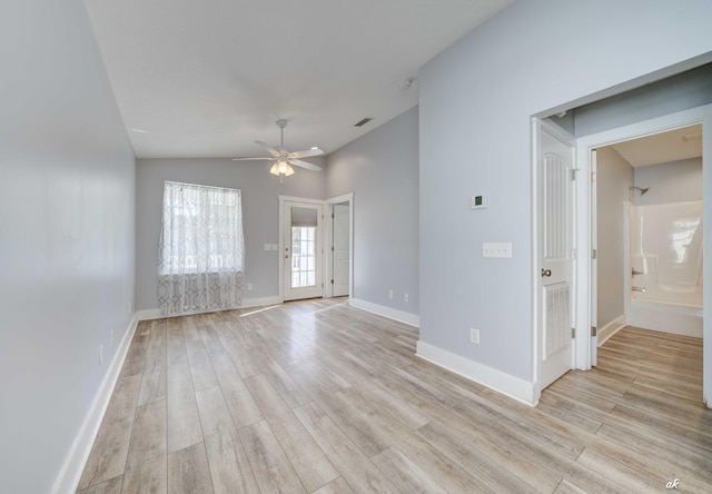 empty room featuring light hardwood / wood-style floors, vaulted ceiling, and ceiling fan