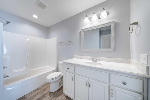 full bathroom with bathing tub / shower combination, vanity, wood-type flooring, and toilet