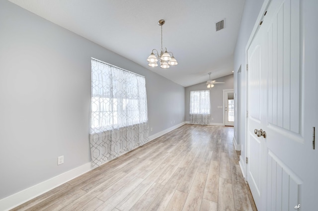 unfurnished room with light wood-type flooring, ceiling fan with notable chandelier, and lofted ceiling