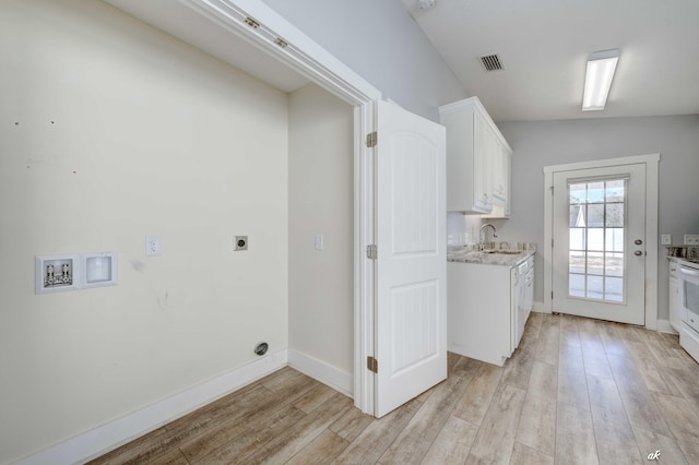 laundry area featuring hookup for an electric dryer, light hardwood / wood-style flooring, and sink