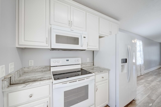 kitchen with light stone counters, white cabinetry, light hardwood / wood-style floors, and white appliances