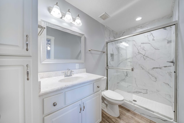 bathroom featuring toilet, a shower with shower door, a textured ceiling, and hardwood / wood-style flooring