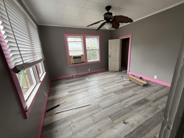 unfurnished room with ceiling fan, cooling unit, light wood-type flooring, and ornamental molding