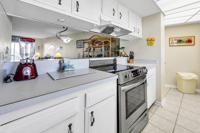 kitchen with white cabinetry, stainless steel electric range oven, light tile patterned floors, and hanging light fixtures