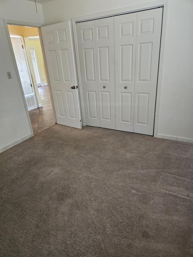 unfurnished bedroom with carpet flooring and a closet