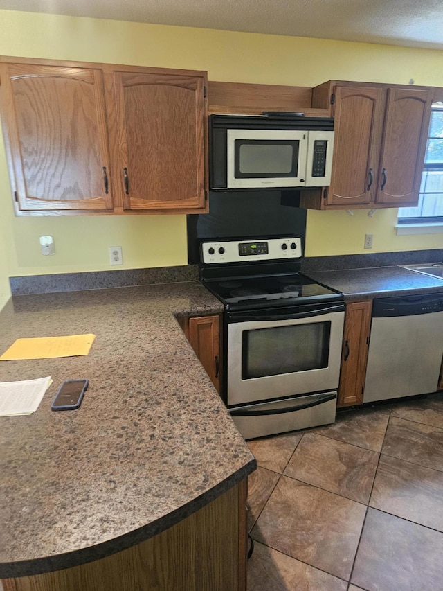 kitchen featuring dark tile patterned floors and stainless steel appliances