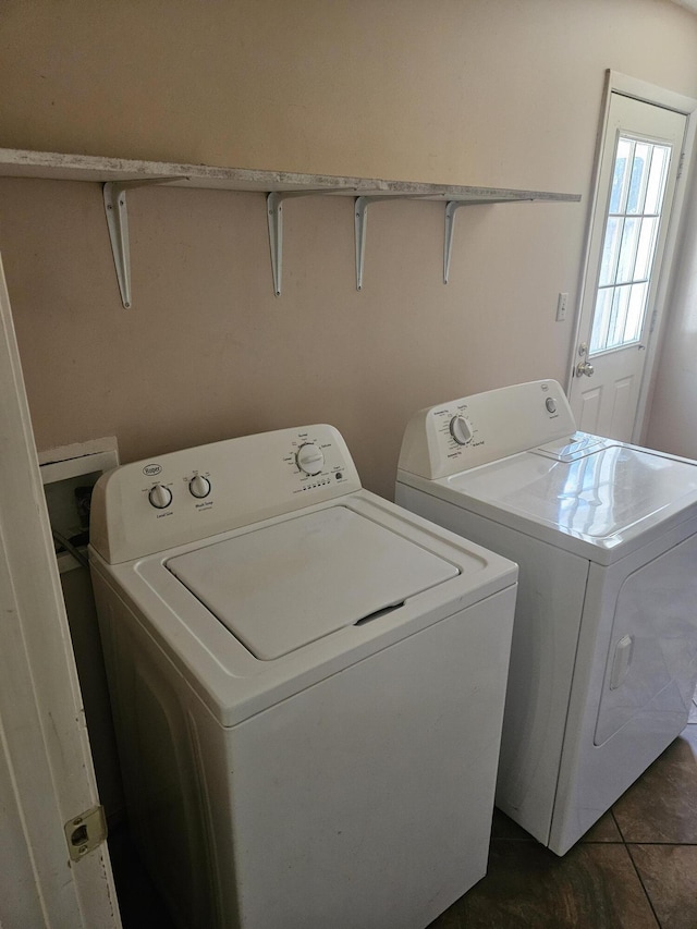 clothes washing area with washing machine and dryer and dark tile patterned floors