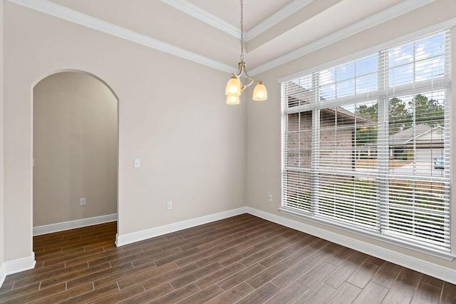 spare room with a chandelier, dark hardwood / wood-style flooring, a tray ceiling, and ornamental molding