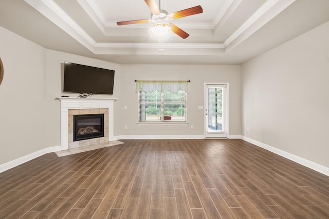 unfurnished living room with a fireplace, dark hardwood / wood-style floors, a raised ceiling, and crown molding