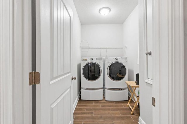 laundry area with a textured ceiling and washing machine and dryer