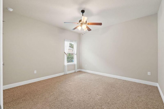 unfurnished room with ceiling fan and carpet