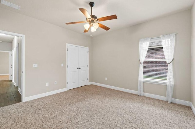 unfurnished bedroom featuring carpet flooring, ceiling fan, and a closet