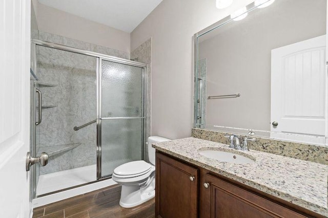 bathroom with vanity, an enclosed shower, and toilet