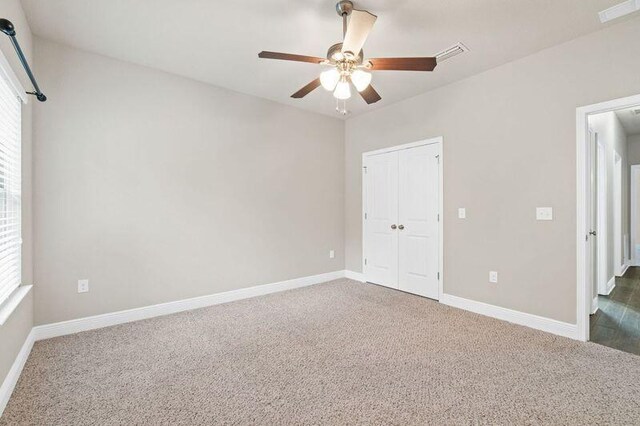 unfurnished bedroom with multiple windows, ceiling fan, a closet, and carpet