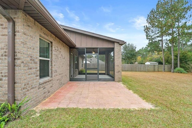 property entrance with a lawn and a patio