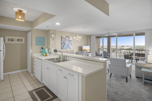 kitchen featuring kitchen peninsula, a textured ceiling, white appliances, sink, and white cabinets