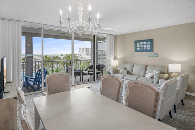 carpeted dining space featuring floor to ceiling windows, ceiling fan with notable chandelier, and a textured ceiling