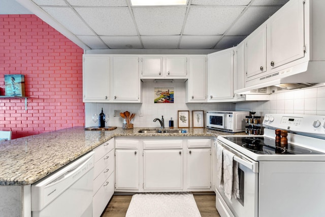 kitchen with white cabinetry, a drop ceiling, white appliances, and sink